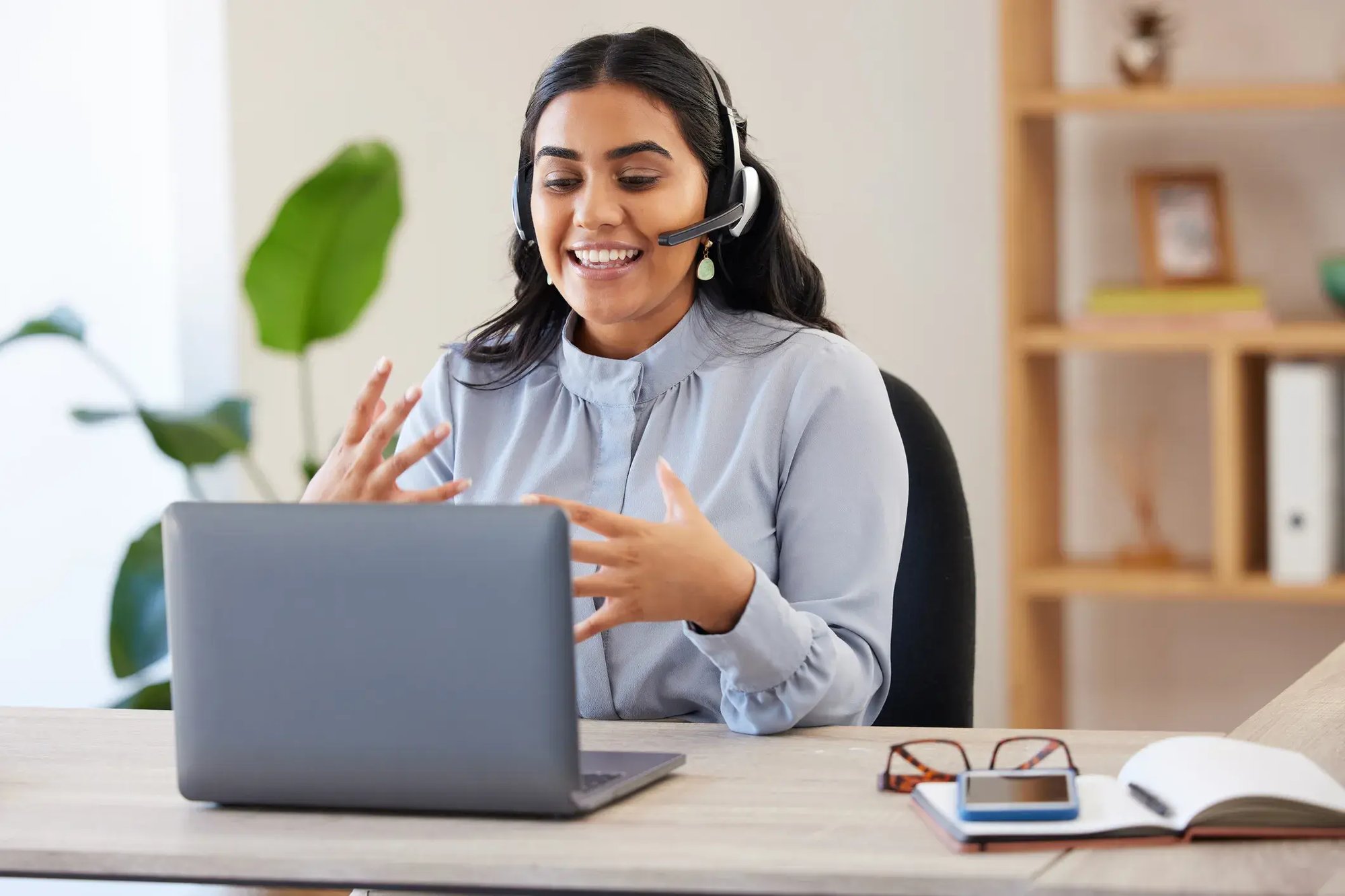 Woman wearing headset talking to coworker with Microsoft Teams Phone