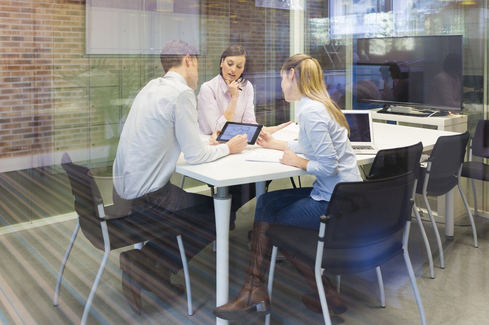 Coworkers reviewing plan on tablet