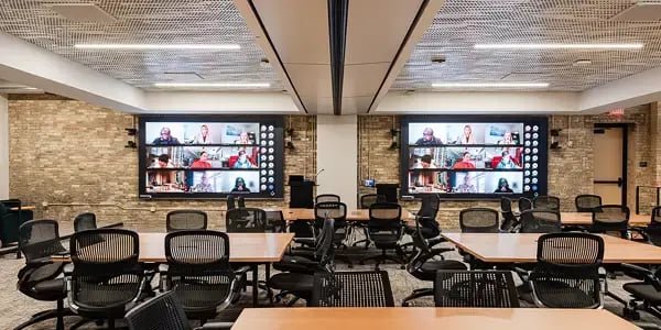 large training room with two identical displays hosting a conference call