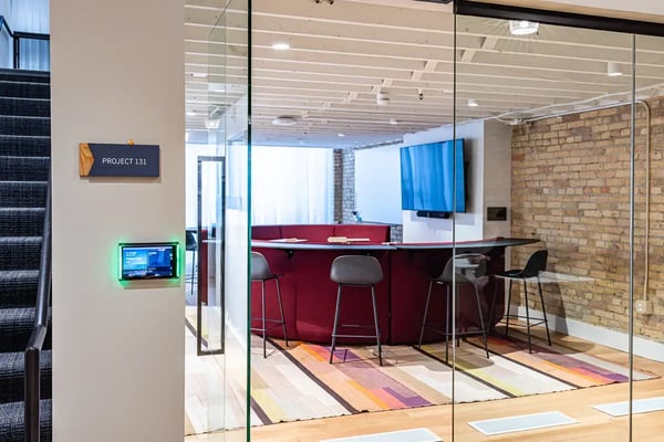 conference room with a large bar style seating arrangement around a display hosting microsoft teams