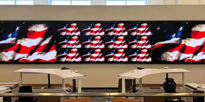 Large extended mission-critical display positioned in front of workstations.