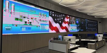 Large, curved LED wall containing charts, graphs, and an American flag.
