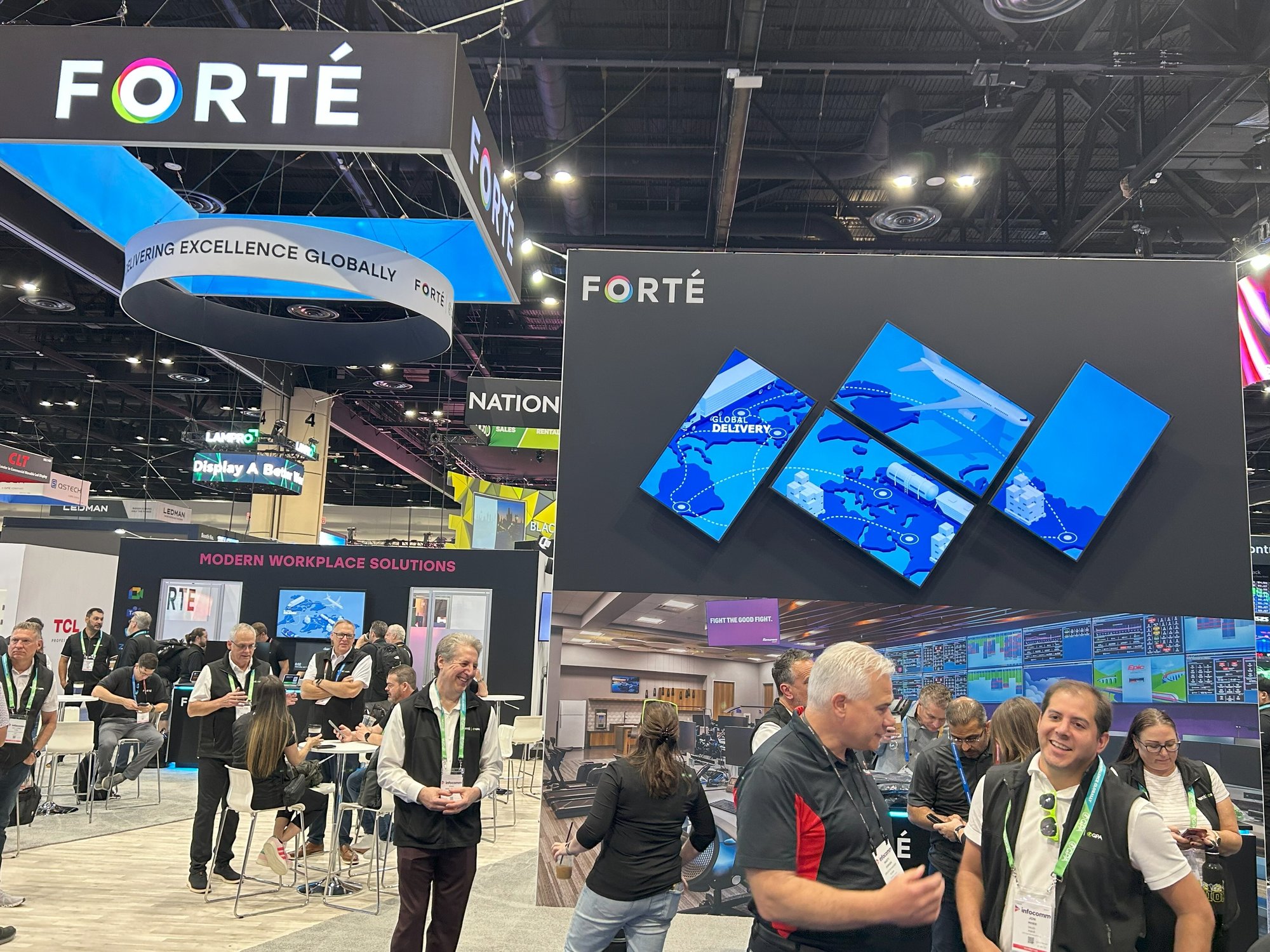 The FORTÉ booth at a trade show convention, featuring prominent branded signage, a suspended ring display with the tagline 