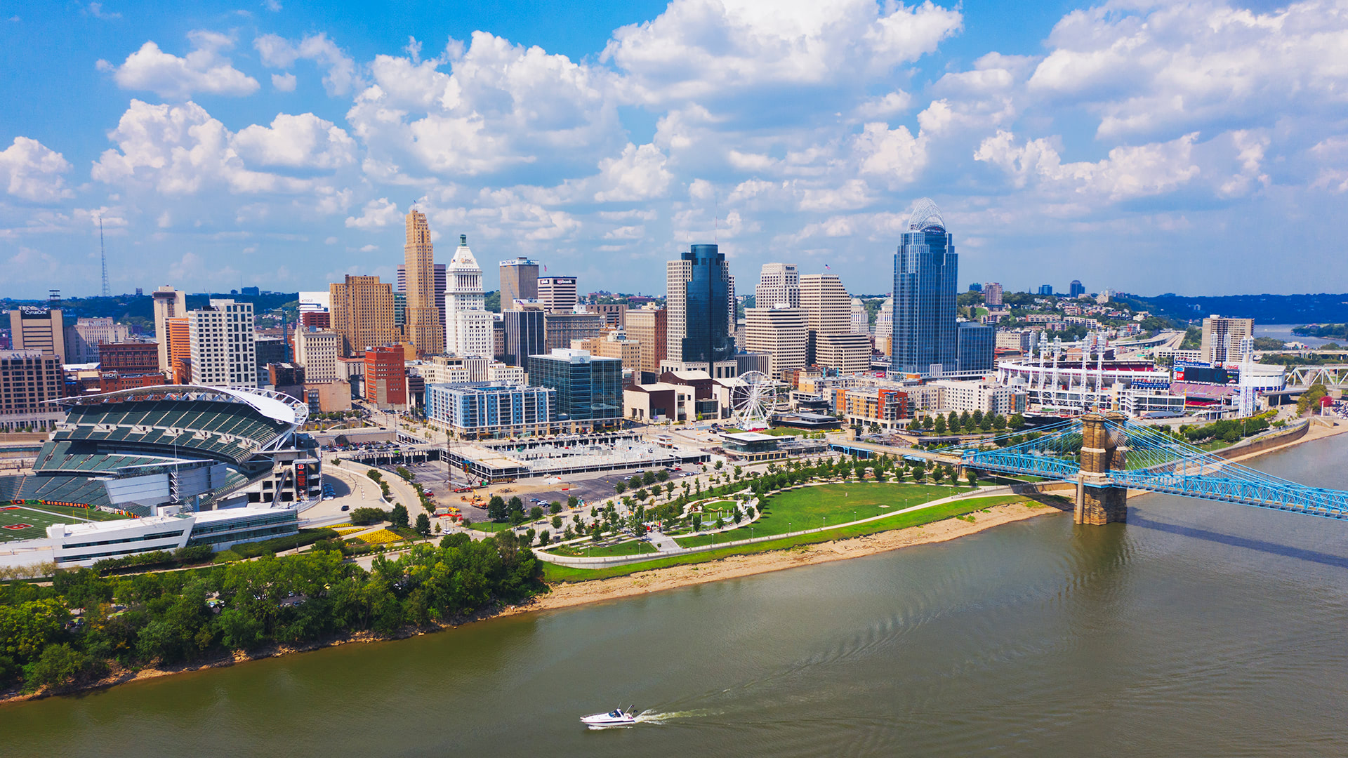 Aerial view of Cincinnati skyline with a focus on riverfront areas and stadiums.