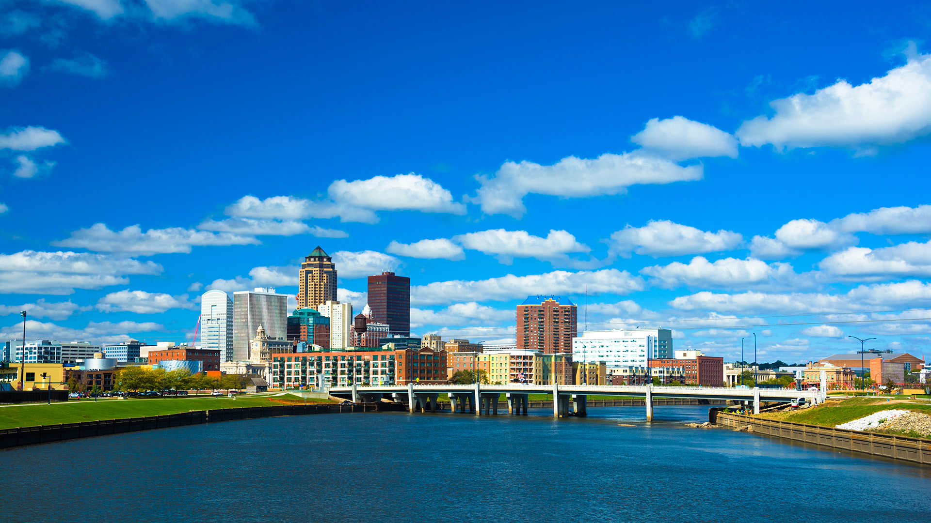 Des Moines skyline with buildings under a blue sky with clouds, symbolizing FORTÉ's global reach and efficiency in AV technology integration.